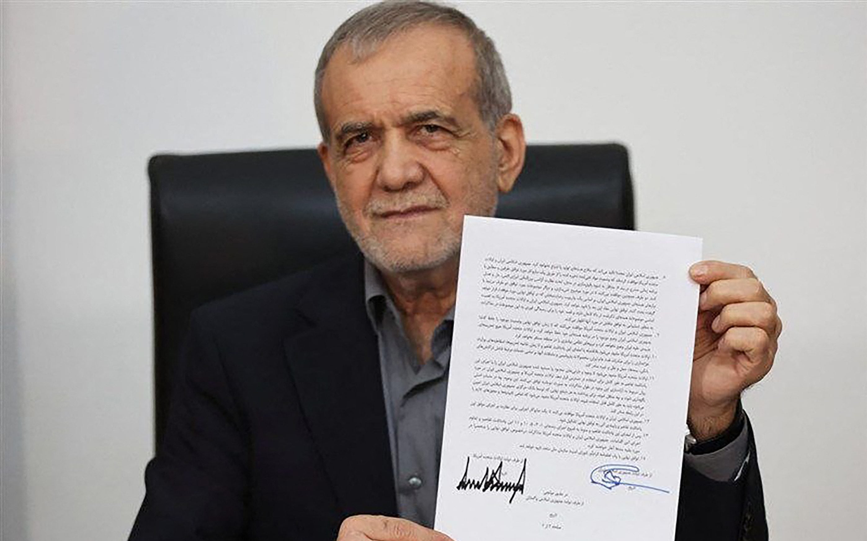Iran President Masoud Pezeshkian displaying the memorandum of understanding signed to end the 2026 Iran-US war