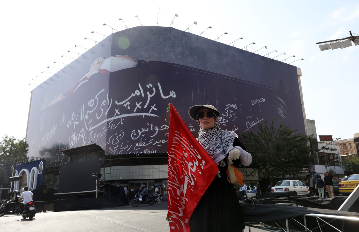 Iranian woman next to anti-US billboard depicting Donald Trump in coffin at Enghelab Square Tehran Iran 2026