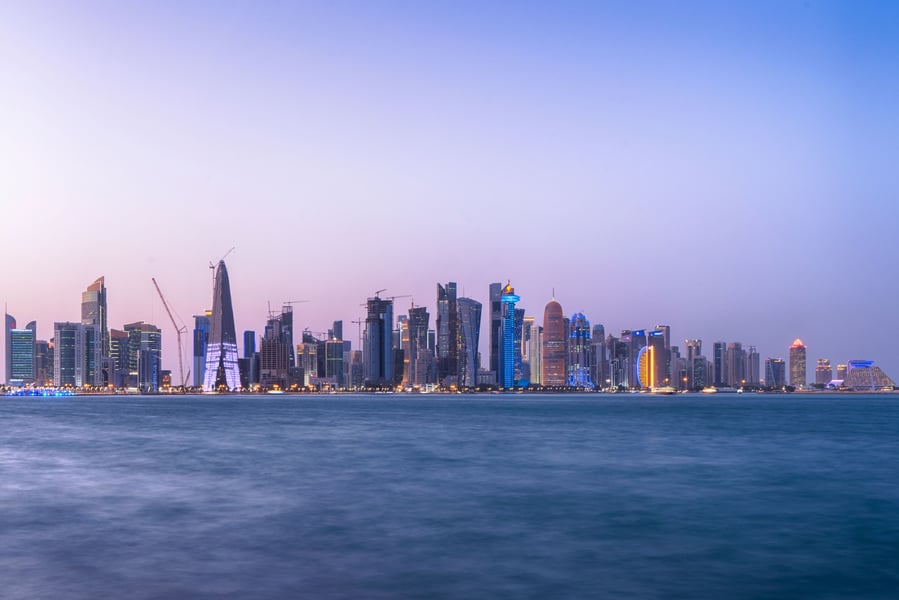 Doha Bay waterfront and West Bay skyline at twilight, Qatar, where Iranian, Qatari, and Pakistani officials held indirect talks on the Islamabad Memorandum of Understanding