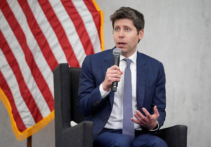 OpenAI CEO Sam Altman with American flag background at a Washington AI policy event