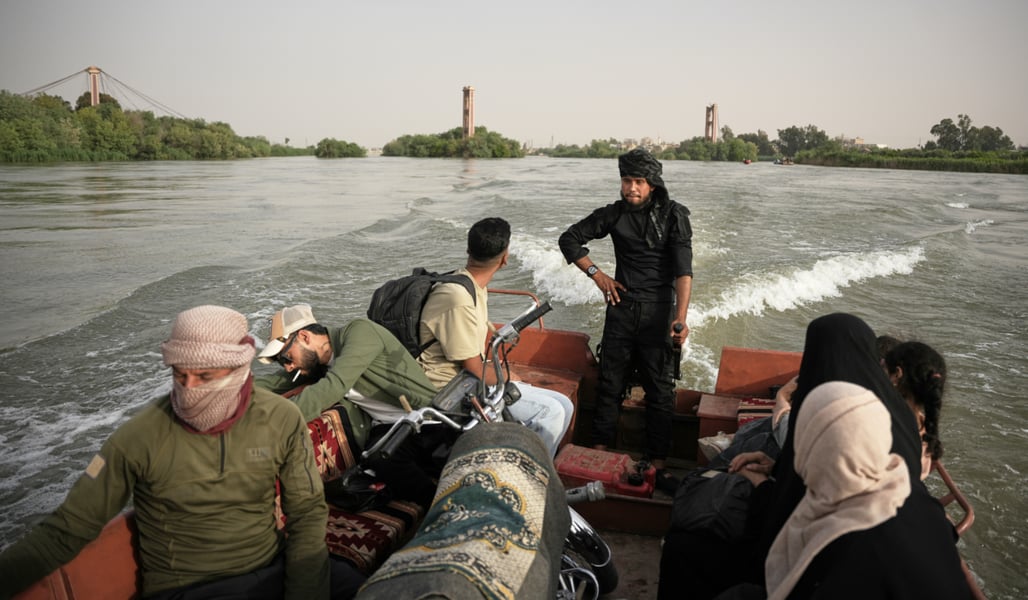 Residents travel by boat along the flooded Euphrates River near Deir Ezzor Syria where a ferry accident killed two children