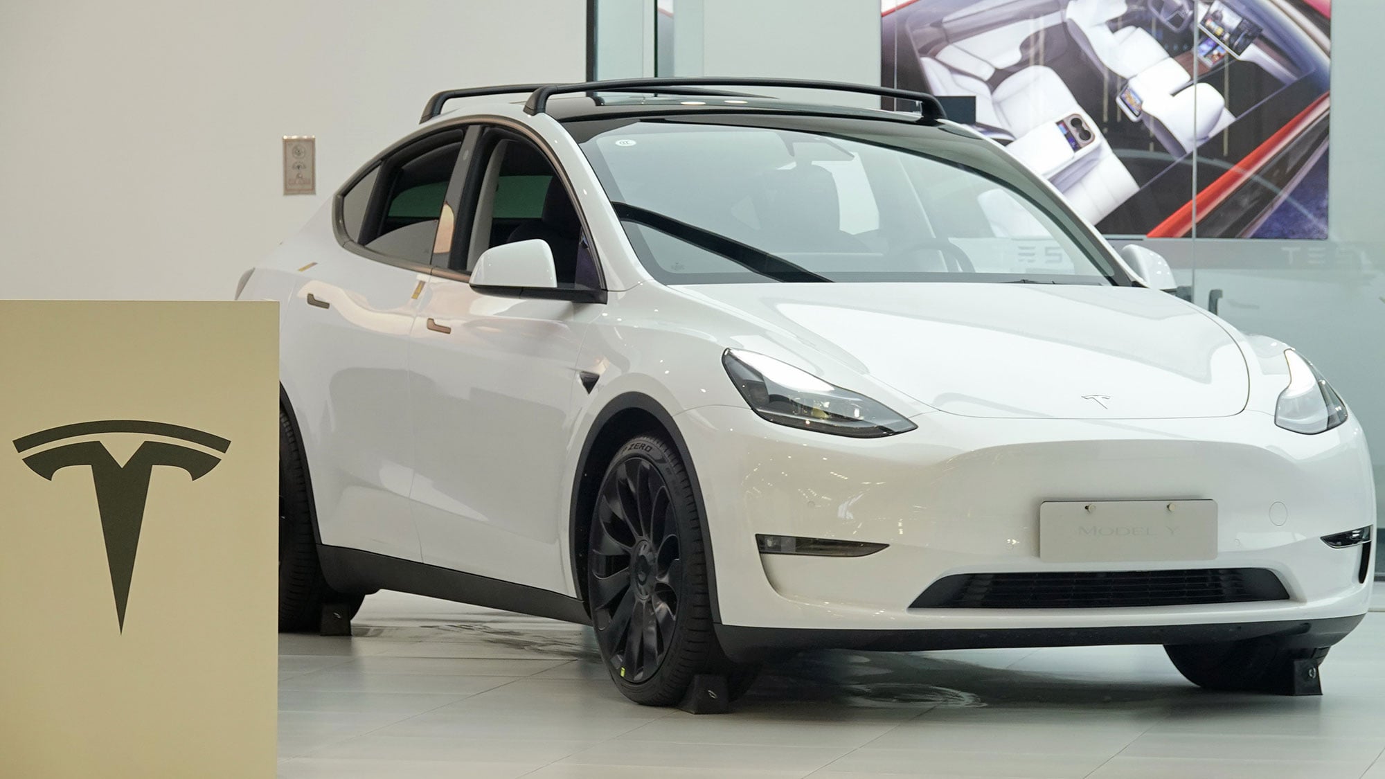 A white Tesla vehicle on a road, representing the NTSB and NHTSA investigation into Tesla Full Self-Driving crashes
