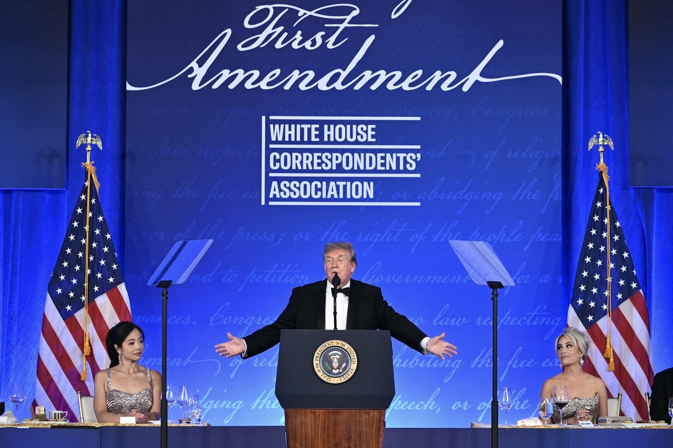 Donald Trump at the White House Correspondents' Dinner holding a Trump 2028 hat