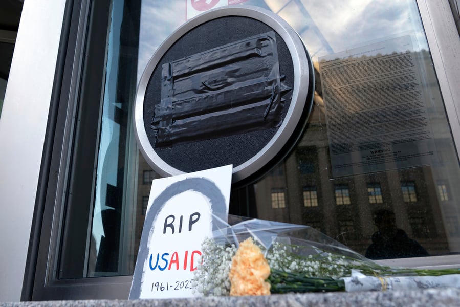 Flowers and signs outside the USAID headquarters in Washington on February 7, 2025, after the Trump administration began dismantling the agency