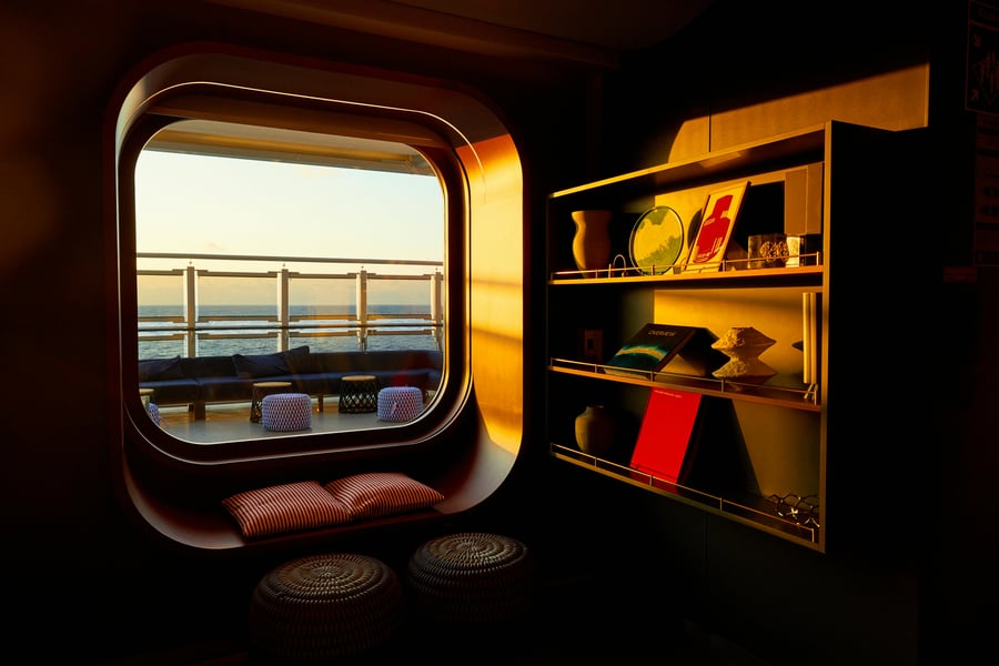Interior of Virgin Voyages Scarlet Lady cruise ship with porthole ocean view, chartered by Atlantis Events for LGBTQ Athens-to-Venice voyage