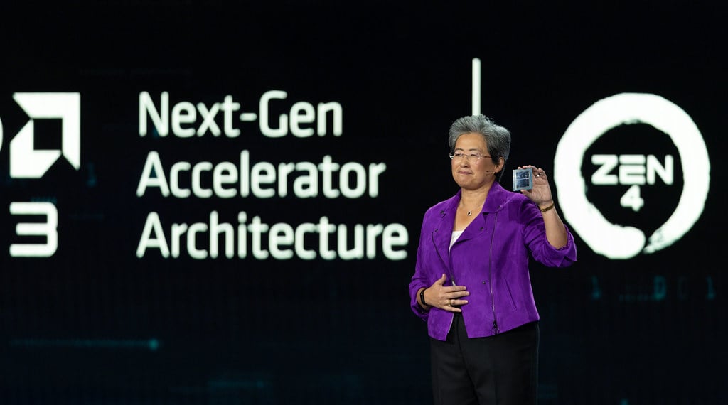AMD CEO Lisa Su on stage holding a chip at an AMD Next-Gen Accelerator Architecture and Zen 4 presentation