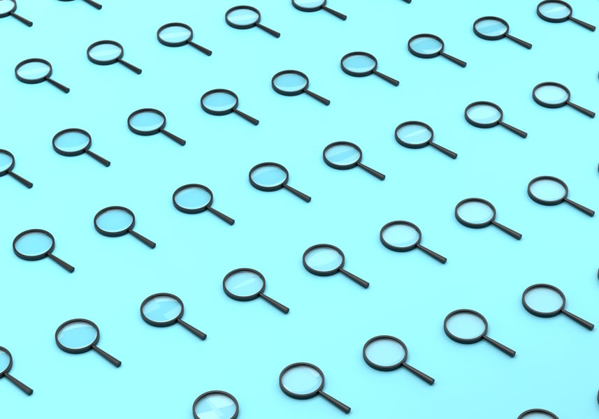 Magnifying glass over digital text representing AI watermark detection technology