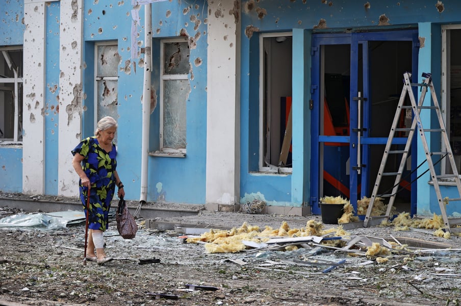 A woman walks past a damaged building in Belgorod, Russia, after a Ukrainian drone attack in August 2026 during the Ukraine war