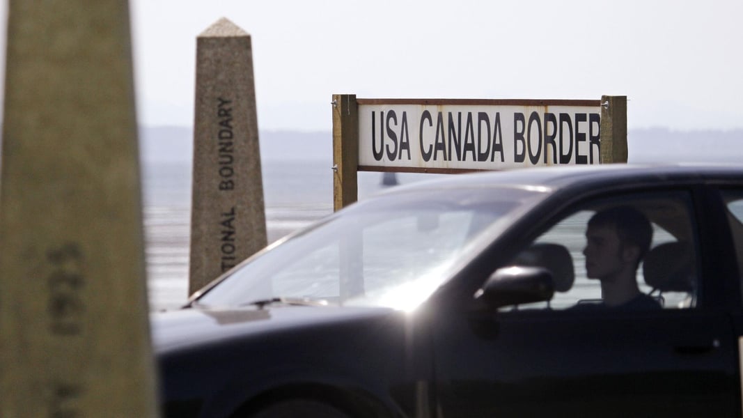 Canadian flag and US-Canada border trade crossing tariffs retaliation