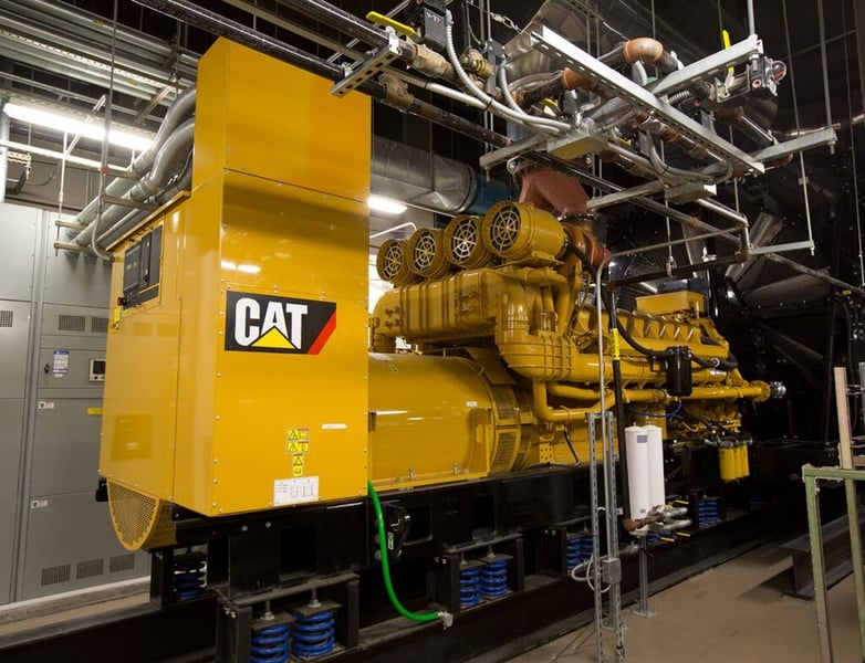A Caterpillar generator set installed inside a data center power room providing primary power for AI infrastructure