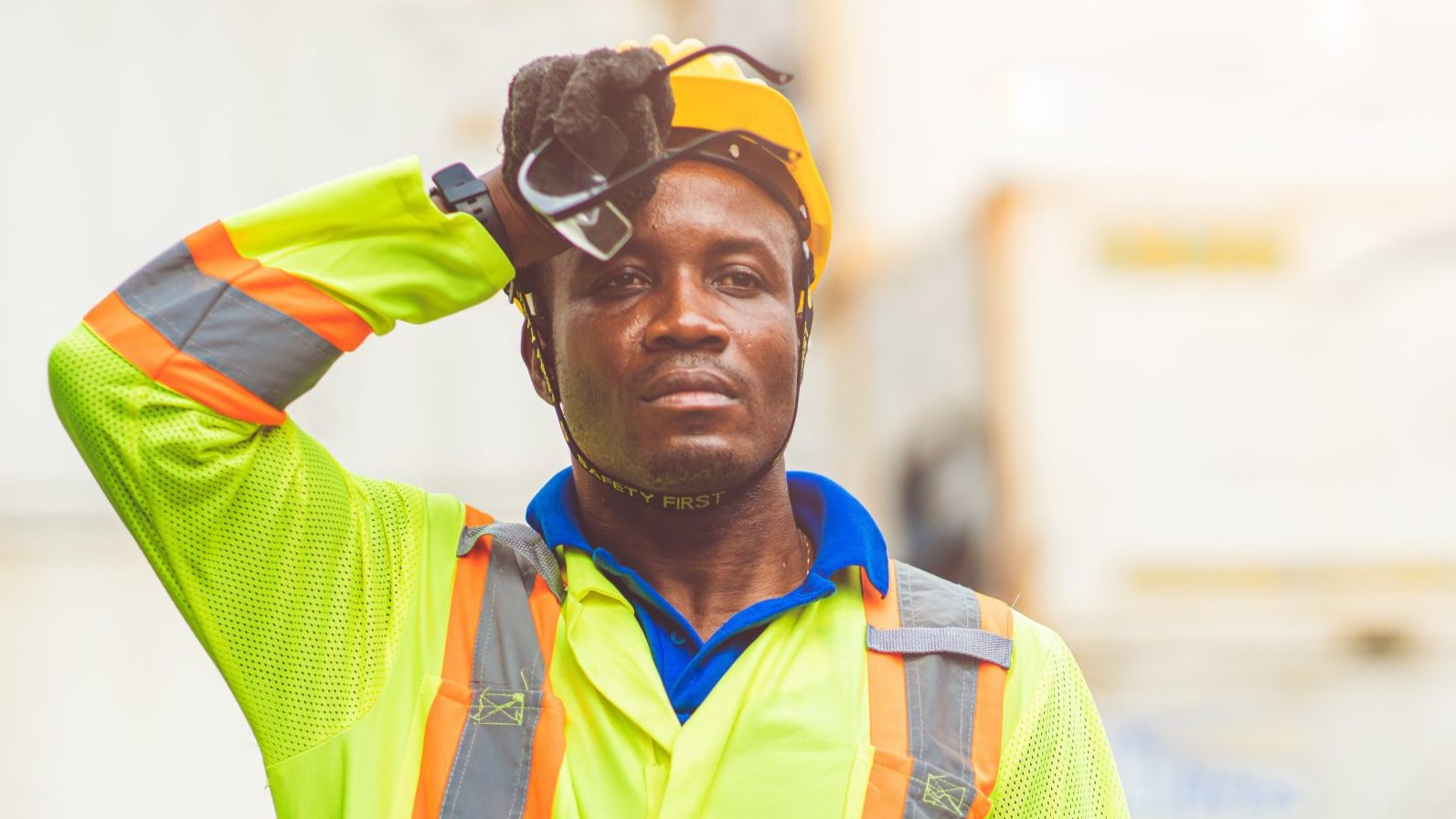 Outdoor worker wiping brow in heat, illustrating the risk of sun poisoning from prolonged UV exposure