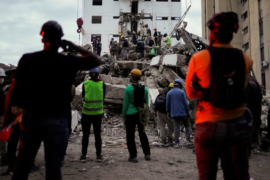 Search and rescue teams work through rubble in Cali Colombia following the 7.4 magnitude earthquake