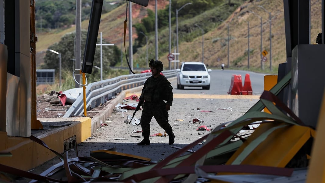 A Colombian soldier walks through debris at a wrecked highway toll plaza