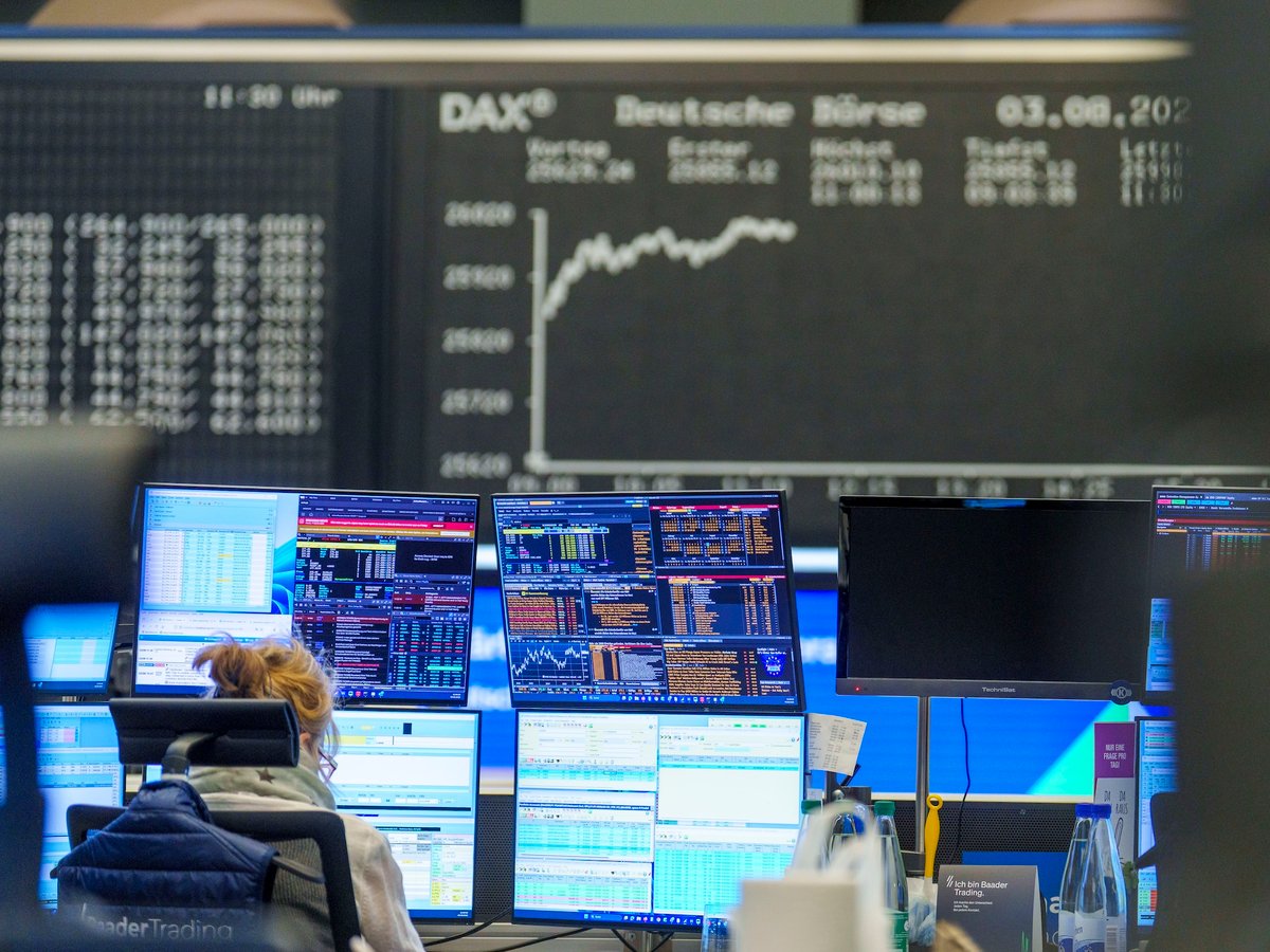 Female trader at Frankfurt stock exchange trading desk as Germany's DAX index reaches record high of 26,000 points on August 3 2026
