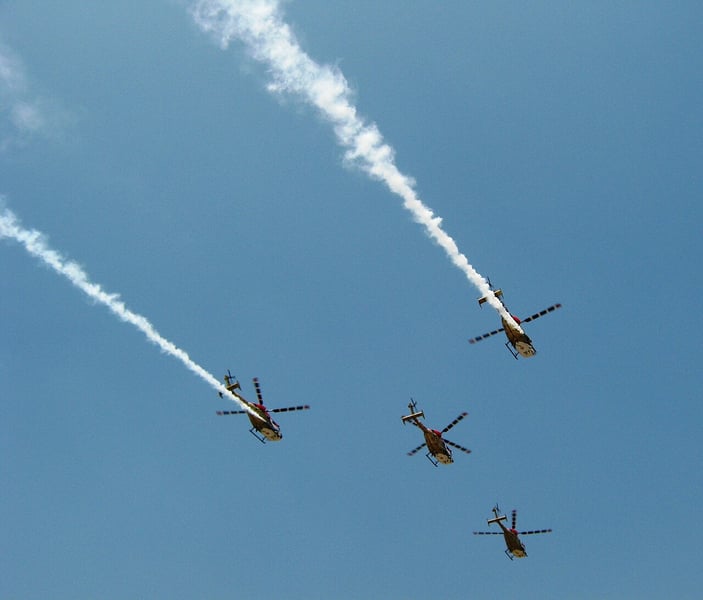 The Indian Air Force Sarang display team flying HAL Dhruv helicopters at Aero India, the showcase for India's listed defence manufacturers
