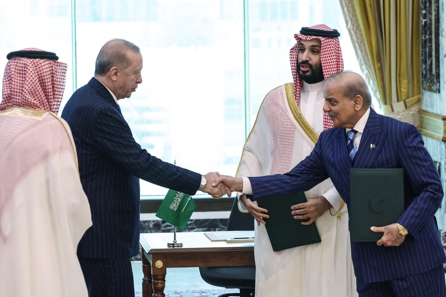 Erdogan shakes hands with Pakistan PM Shehbaz Sharif as Saudi Crown Prince Mohammed bin Salman looks on after signing the Mecca joint defence agreement