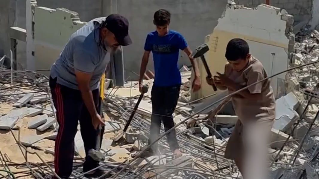 Palestinian father and sons clearing rubble in Gaza amid ongoing Israeli military campaign August 2026
