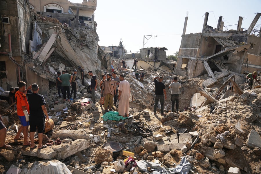 Palestinians inspect destroyed buildings at Maghazi refugee camp in central Gaza following Israeli air strikes, August 2026