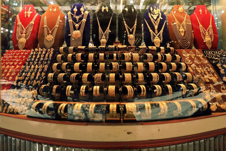 Gold necklaces, bangles and rings filling a jeweller's display window, the worked pieces on which making charges are highest