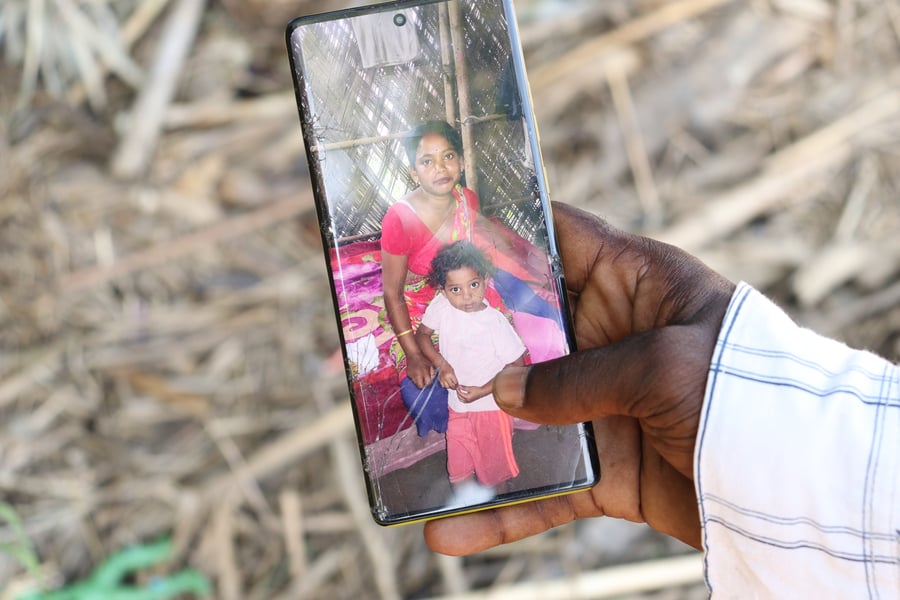 Debiram Panika holds his phone showing photos of his wife and daughter who died in the Assam floods 2026