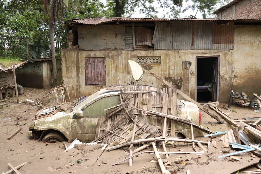 Car submerged in silt in front of a flood-damaged home in Sivasagar district, Assam, India 2026