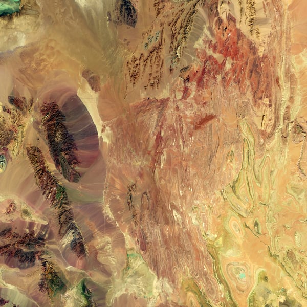 NASA Landsat 8 false-color satellite image showing the arid landscape of central Iran in vivid shortwave infrared colors, revealing the country's vast desert terrain