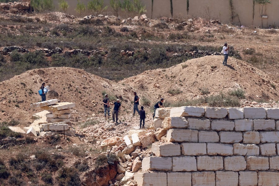 Israeli settlers gathered outside Palestinian homes blockaded in Qusra village south of Nablus in the West Bank