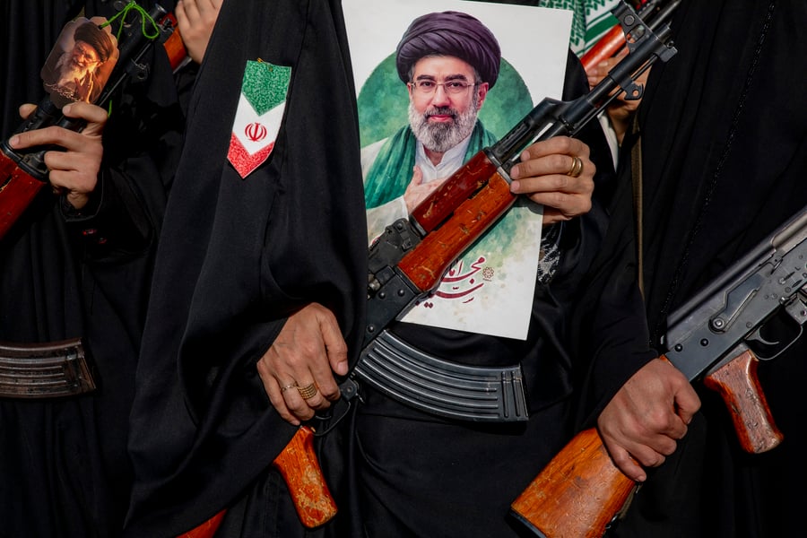 Women carrying rifles with portrait of Mojtaba Khamenei at pro-government demonstration in Tehran, April 2026