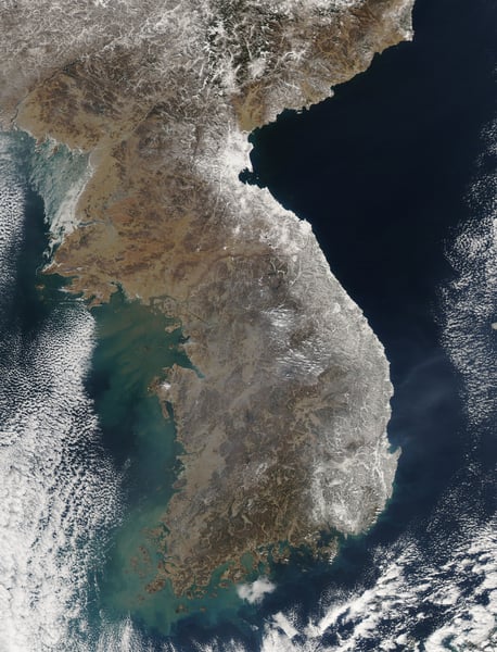 NASA MODIS satellite image showing the Korean Peninsula covered in heavy snow in February 2011, with South Korea's coastal regions and mountain ranges clearly visible from space