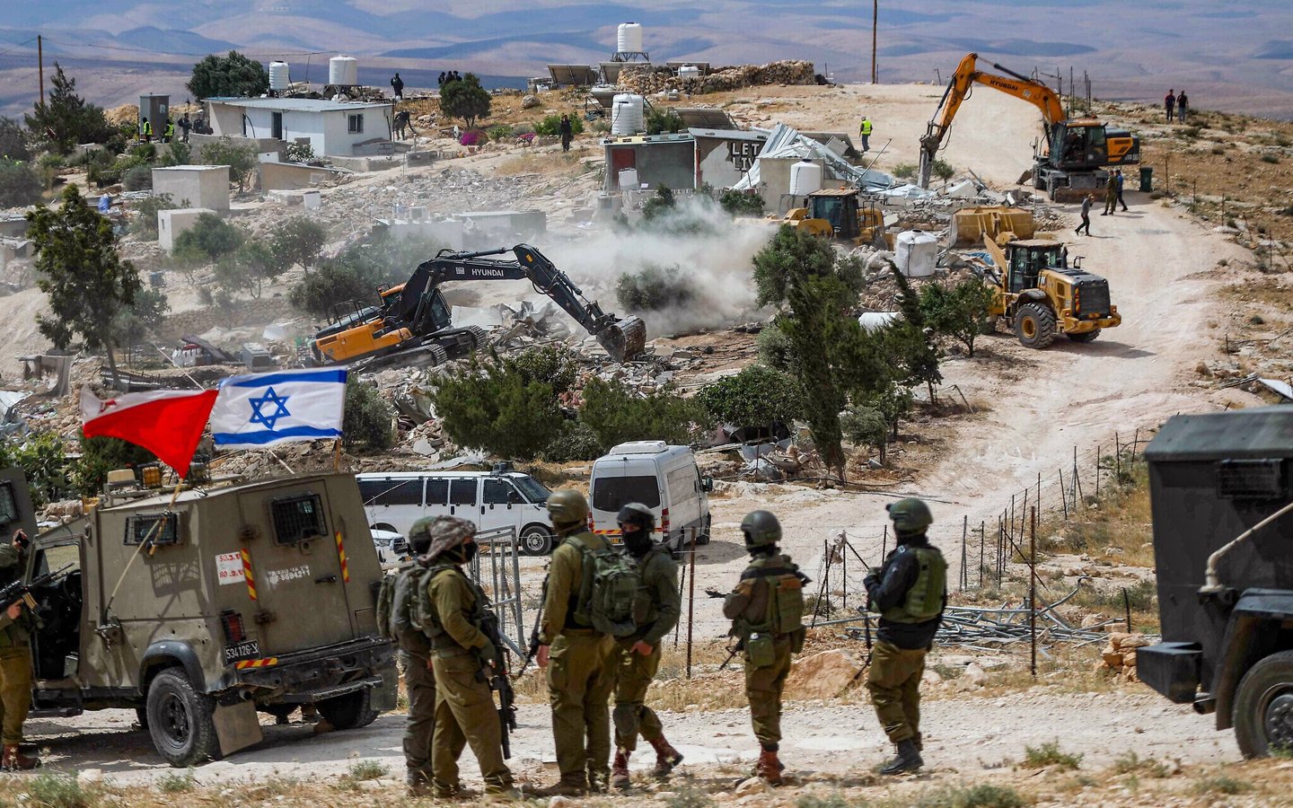 Israeli soldiers stand guard while bulldozers demolish Palestinian structures in Ed-Daba village Masafer Yatta West Bank south of Hebron May 2025