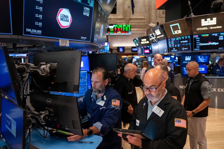 Nasdaq futures today: traders work at screens on the floor of the New York Stock Exchange beneath price tickers
