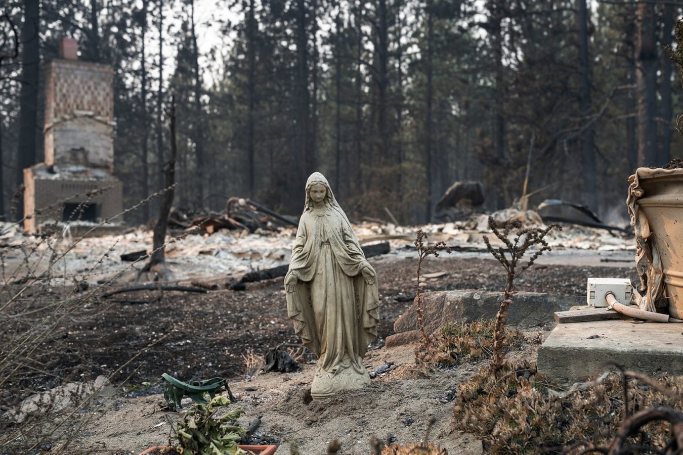 A Virgin Mary statue stands undamaged amid burned ruins of homes in Spokane's Balboa neighborhood after the Old Trails Fire August 2026
