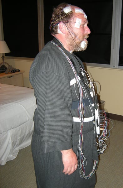 Person wired up with EEG electrodes for overnight sleep study polysomnography