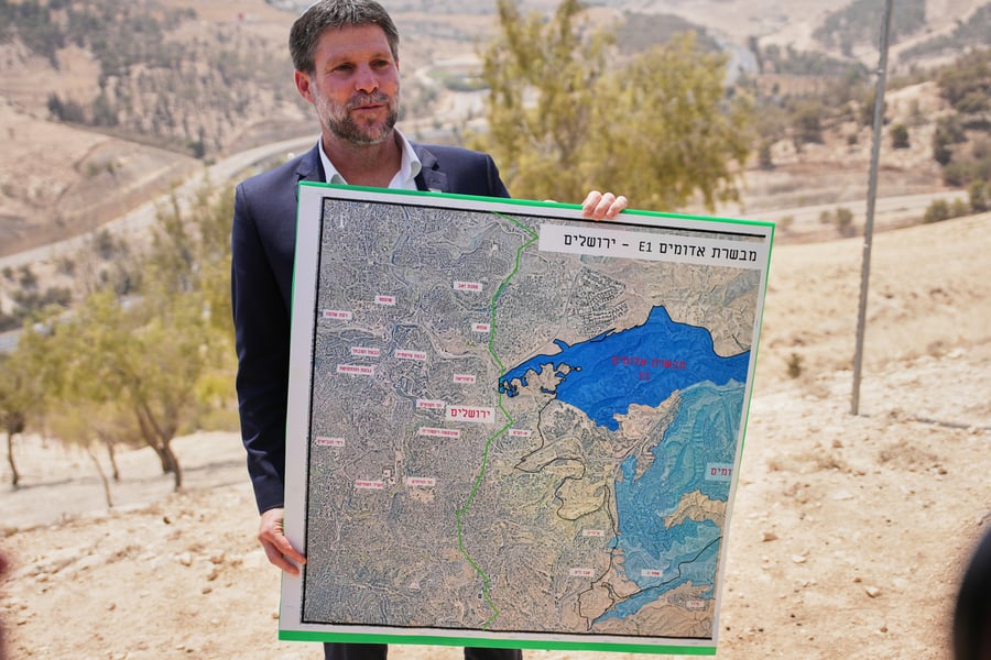 Bezalel Smotrich holds map of E1 West Bank settlement project near Maale Adumim