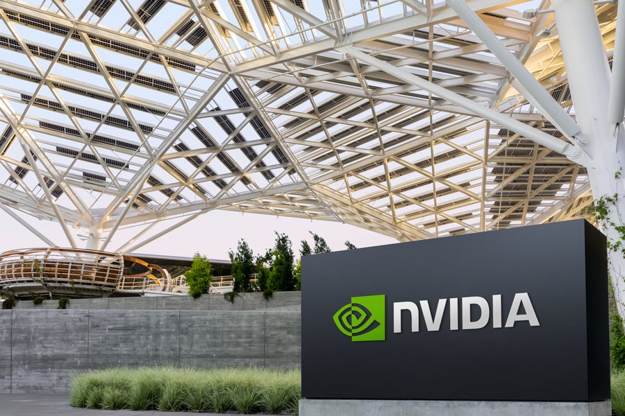 The NVIDIA sign outside the company Santa Clara headquarters beneath the steel and solar canopy of the Voyager building at dusk