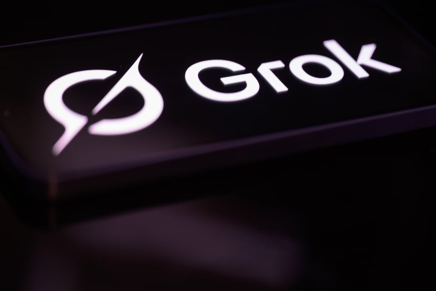 Grok AI logo on smartphone representing SpaceX and xAI's GPU expansion following Cursor acquisition
