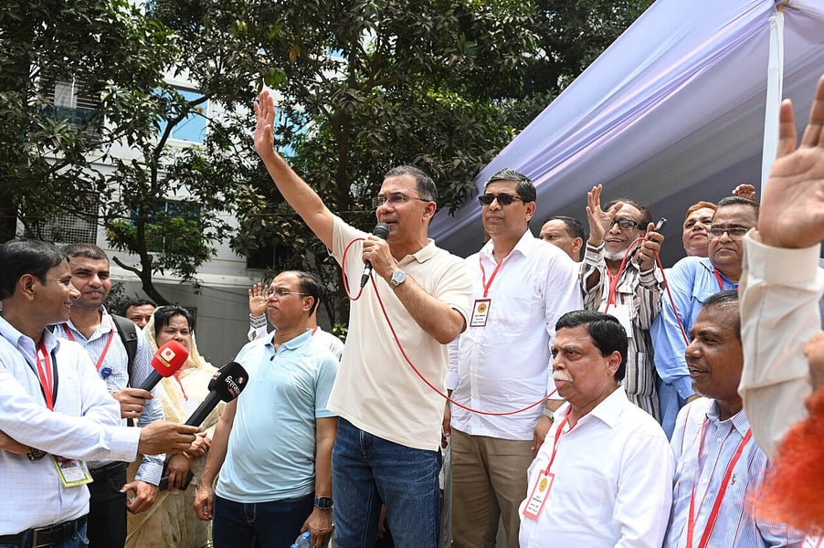 Tarique Rahman speaking into a microphone with his arm raised at the inauguration of Bogura City Corporation
