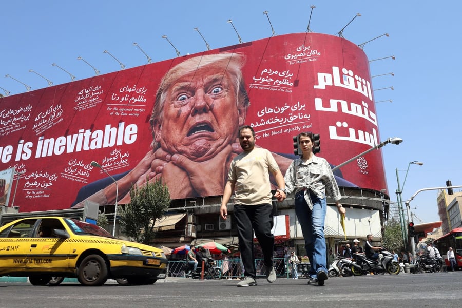 Iranians walk in front of an anti-Trump billboard in Tehran as Washington escalates its sanctions campaign