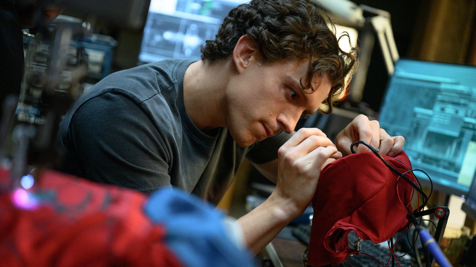 Tom Holland as Peter Parker repairing his suit in Spider-Man Brand New Day