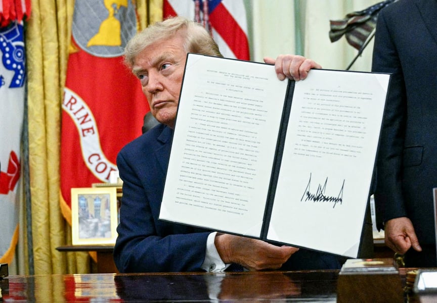 President Donald Trump holds up a newly signed executive order in the Oval Office of the White House on August 6, 2026