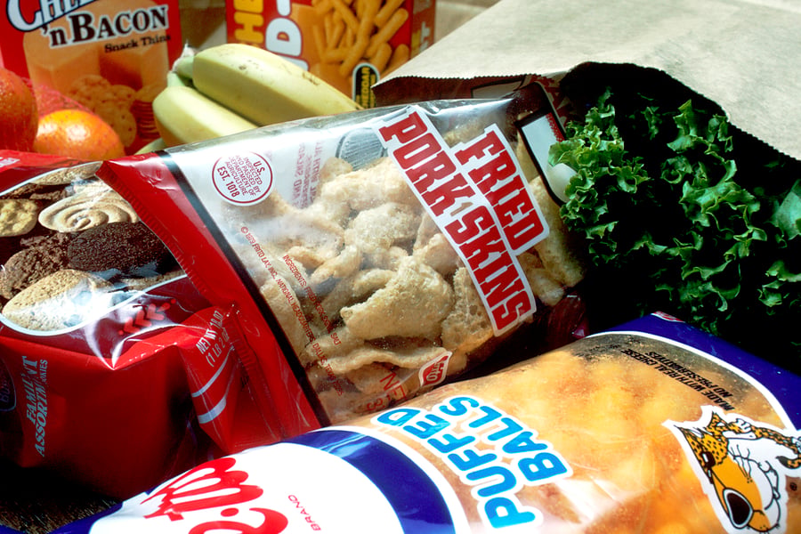 Grocery bag overflowing with ultra-processed food packages