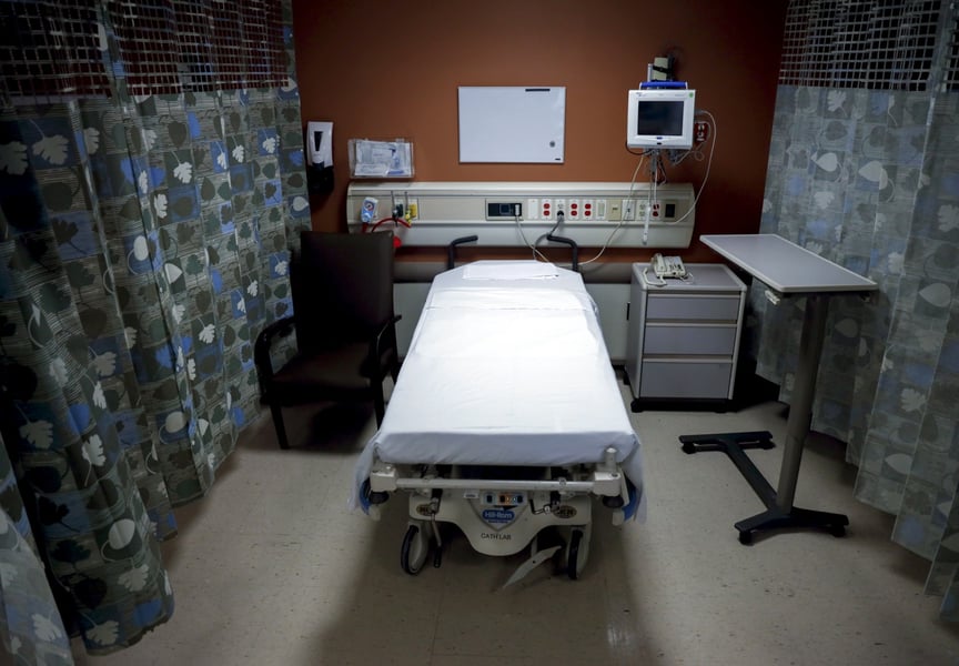 An empty hospital bed in a US hospital room as employer health insurance costs rise