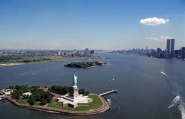 Statue of Liberty in New York Harbor with the Twin Towers visible in the background