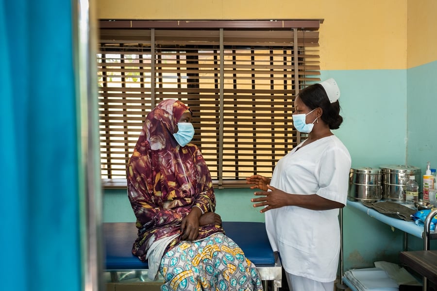 A healthcare worker and patient during an HPV and cervical cancer awareness session, illustrating the public health outreach the NHS England home-test programme aims to supplement
