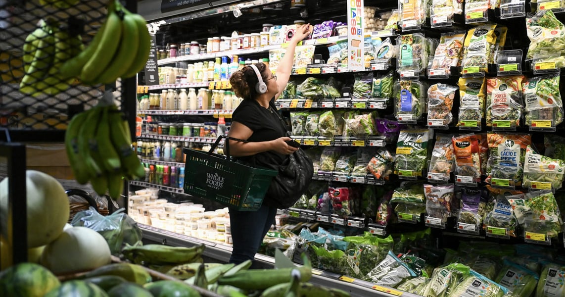 Shopper in grocery store aisle amid rising inflation in August 2026 driven by Iran war oil prices