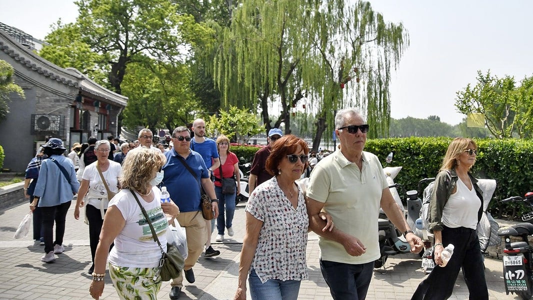 Foreign tourists at Houhai lake in Beijing, where China's tightened exit ban rules now carry legal force under Decree 841