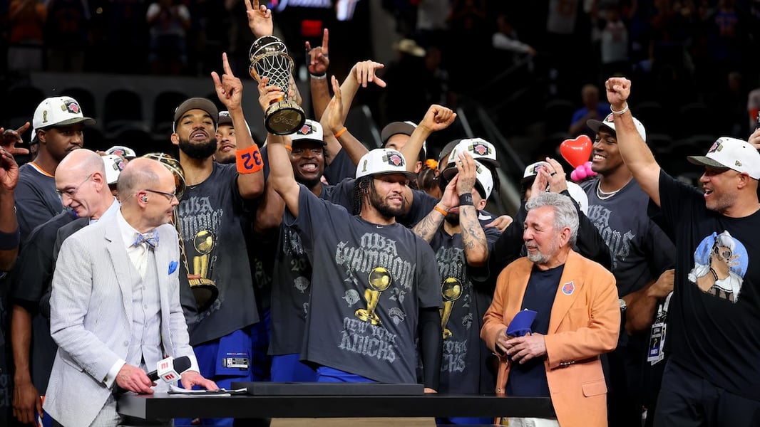 Jalen Brunson holding the Bill Russell Trophy after winning the 2026 NBA Finals MVP award