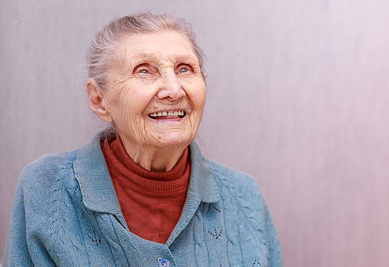 Elderly woman looking out window, representing dementia risk research in adults over 90