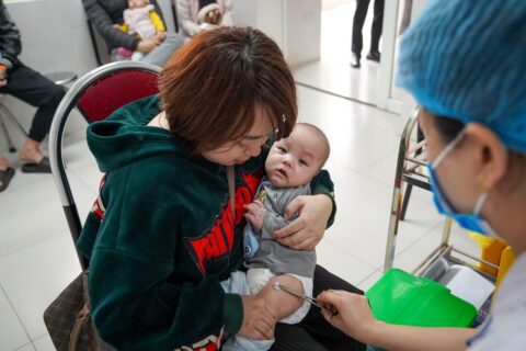 A health worker administers a measles vaccination during a public health campaign, representing efforts to prevent measles spread