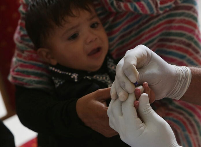 Children outside a government hospital in Sindh, Pakistan, where a pediatric HIV cluster linked to unsafe syringe reuse was identified